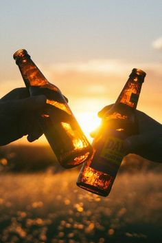 two people toasting beer bottles with the sun setting in the background and text that reads, are you attending athens where to party?