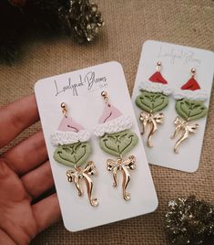 Embrace the holiday spirit with a hint of playful mischief in these charming Grinch-inspired Christmas earrings! Each earring is meticulously handcrafted from lightweight polymer clay, featuring a cute Grinch face with a Santa hat and an elegant gold-toned bow charm. Perfect for adding a unique touch to your Christmas outfit or as a whimsical gift for any Christmas lover, these earrings capture the magic of the season in a delightful and eye-catching way. These earrings are lightweight, comfortable to wear, and finished with a quality gold-tone hook for a secure fit. Whether for a Christmas party, gift exchange, or just spreading cheer in everyday wear, these Grinch-inspired earrings are sure to bring smiles and compliments. Surprise a friend or treat yourself to this festive, handmade pie Grinch Face, Bow Charm, Christmas Clay, Whimsical Gifts, Holiday Earrings, Christmas Lovers, Grinch Christmas