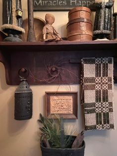 a shelf filled with pots and other items on top of a wall next to a potted plant