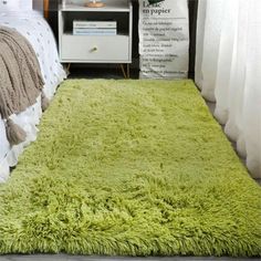 a green rug on the floor in a bedroom