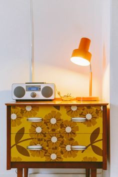 a yellow and brown dresser with a radio on top