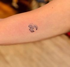 a woman's arm with a tattoo on it that has an image of a cupcake in the shape of a heart