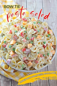 bow tie pasta salad in a white bowl on a yellow and white checkered napkin