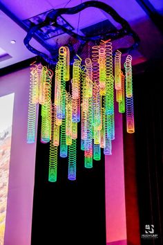 a colorful chandelier hanging from the ceiling in front of a projector screen