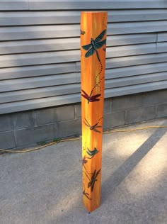 an orange pole with dragonflies painted on it