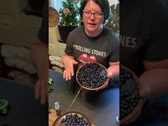 a man holding a bowl full of blueberries