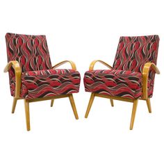 a pair of chairs sitting next to each other on top of a white background with red and black designs