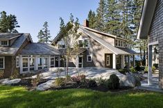 a large house sitting in the middle of a lush green field with lots of trees