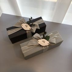 two wrapped gift boxes with ribbons on them