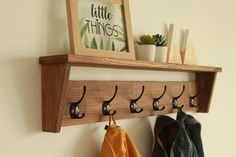 the coat rack has five coats hanging from it's hooks and is next to a potted plant