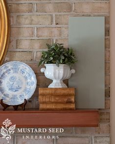 there is a potted plant on top of a shelf next to plates and a mirror