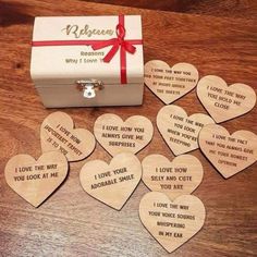 wooden hearts with i love you messages on them sitting next to a small gift box