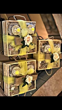 three wooden boxes with flowers and ribbons on them