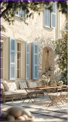 an outdoor seating area with blue shuttered windows