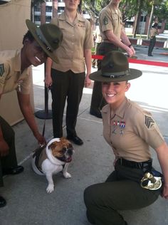 two police officers and a small dog are posing for a photo with their handlers