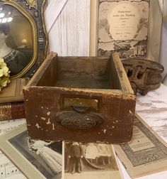 an old wooden box sitting on top of a table next to other antique photos and pictures