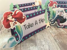 the little mermaid place cards are on display