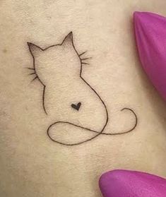 a cat tattoo on the back of a woman's shoulder