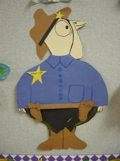 a cardboard cutout of a sheriff dog in blue shirt and cowboy hat with stars on his chest