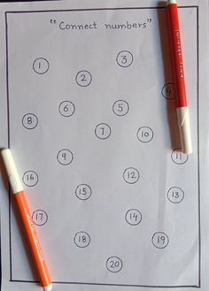 two orange and white pens sitting on top of a sheet of paper with numbers written in it