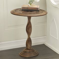 a wooden table with a book on top and flowers in a vase next to it