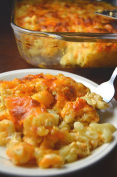 a white plate topped with macaroni and cheese next to a casserole dish