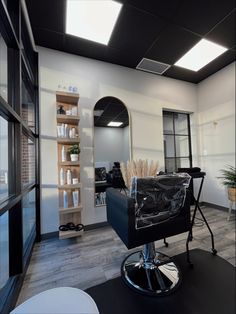 an empty salon room with black chairs and white walls