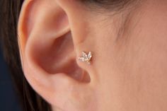 a close up of a person's ear with a small butterfly on the side