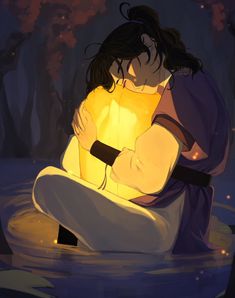 a person sitting in the water with their arms around each other while holding a glowing object