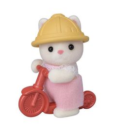 a small white cat with a yellow helmet and pink dress riding a red toy bike