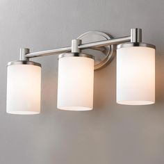 three light bathroom fixture with frosted glass shades on the bottom and white drum lights