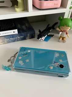 a blue tablet sitting on top of a white table next to a toy and books