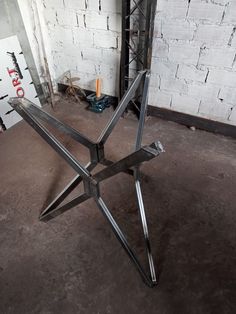 a large metal object sitting on top of a cement floor next to a white brick wall