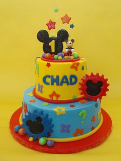 a mickey mouse themed birthday cake on a yellow background