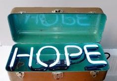 an open suitcase with the word hope written in white letters on it's lid