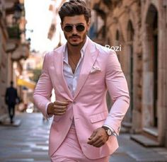 a man in a pink suit is walking down the street with his hands in his pockets