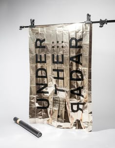 a banner with the words under the radar written on it next to a black pipe