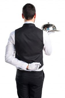 a man in a tuxedo holding a silver platter