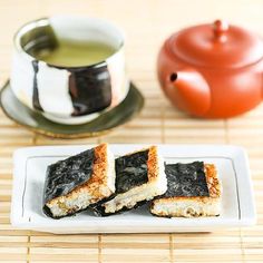 two pieces of food on a plate next to a tea pot