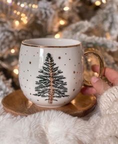 a hand holding a coffee cup with a christmas tree on it