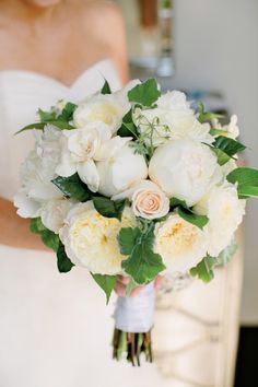 a bridal holding a bouquet of white and yellow flowers