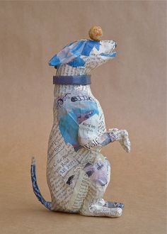 a ceramic dog figurine sitting on its hind legs with a hat on it's head