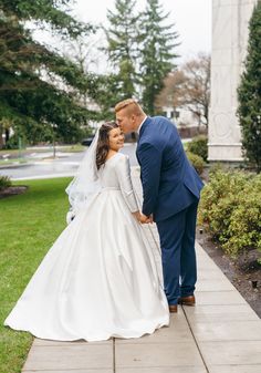 the bride and groom are posing for a photo together in front of a monument at their wedding