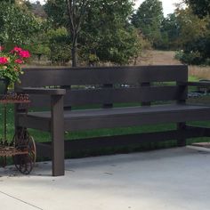 a wooden bench sitting next to a potted plant on top of a metal stand