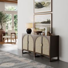 a living room with a painting on the wall next to a sideboard and table