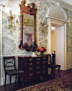 an ornately decorated room with a mirror and dresser in the corner, along with two chairs