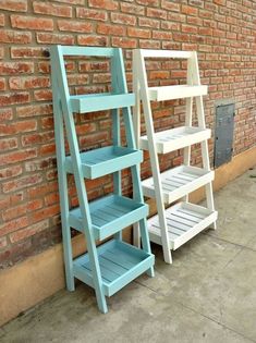 two blue and white wooden shelves against a brick wall next to each other on the sidewalk