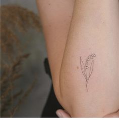 a woman's arm with a small flower tattoo on the left side of her arm