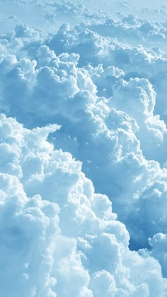 the view from an airplane window looking down on some fluffy white clouds and blue sky