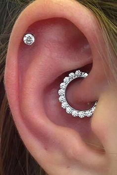 a close up of a person's ear with two piercings